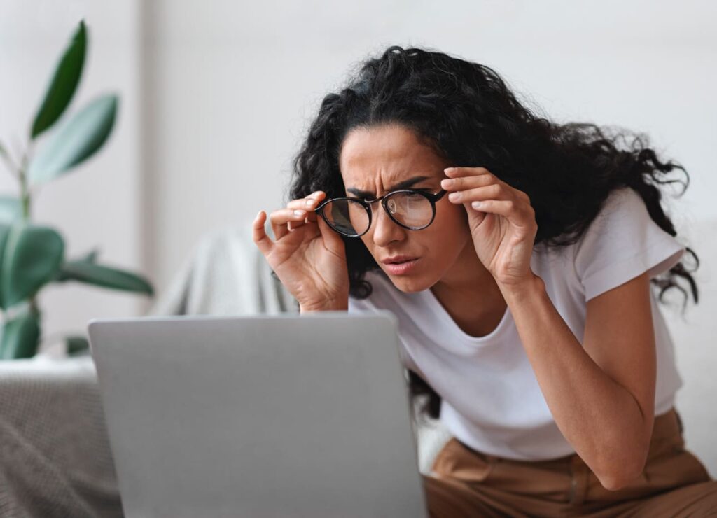 Mujer con astigmatismo mira el ordenador no ve bien