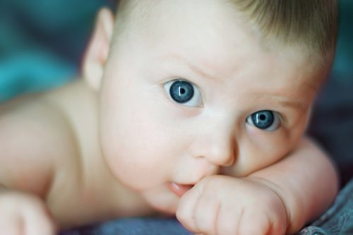 close-up portrait of beautiful baby on blue background